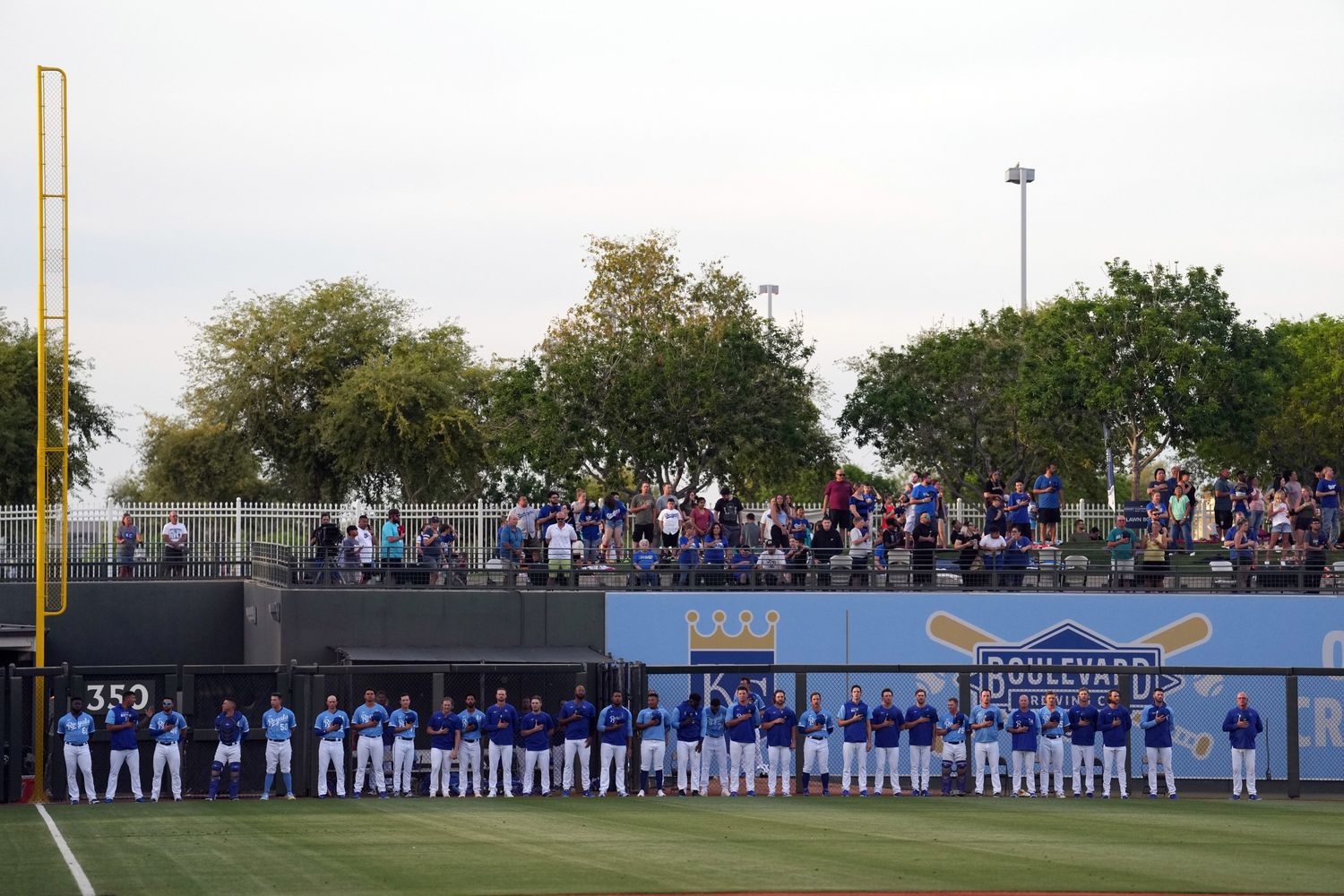 Mar 26, 2022; Surprise, Arizona, USA; Kansas City Royals players look on during the national anthem prior to a spring training game against the Los Angeles Dodgers at Surprise Stadium. Mandatory Credit: Joe Camporeale-USA TODAY Sports